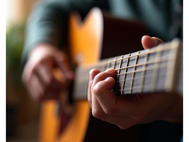 Hands carefully positioned on a guitar fretboard, focusing on concentration and fine motor skills.